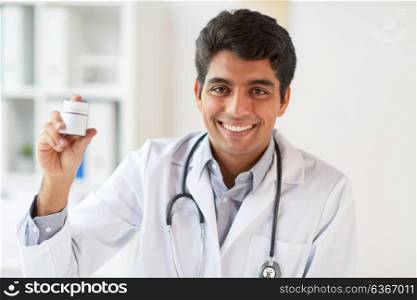 medicine, healthcare and people concept - happy smiling male doctor with stethoscope and medication at clinic. happy doctor with stethoscope and medication