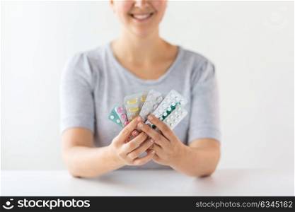 medicine, healthcare and people concept - happy woman holding packs of pills. happy woman holding packs of pills