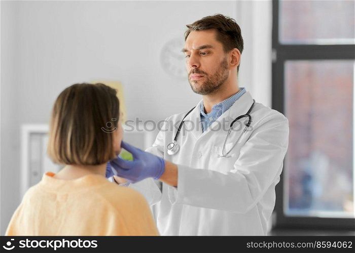 medicine, healthcare and people concept - male doctor checking lymph nodes of woman patient at hospital. doctor checking lymph nodes of woman at hospital