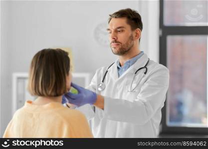 medicine, healthcare and people concept - male doctor checking lymph nodes of woman patient at hospital. doctor checking lymph nodes of woman at hospital