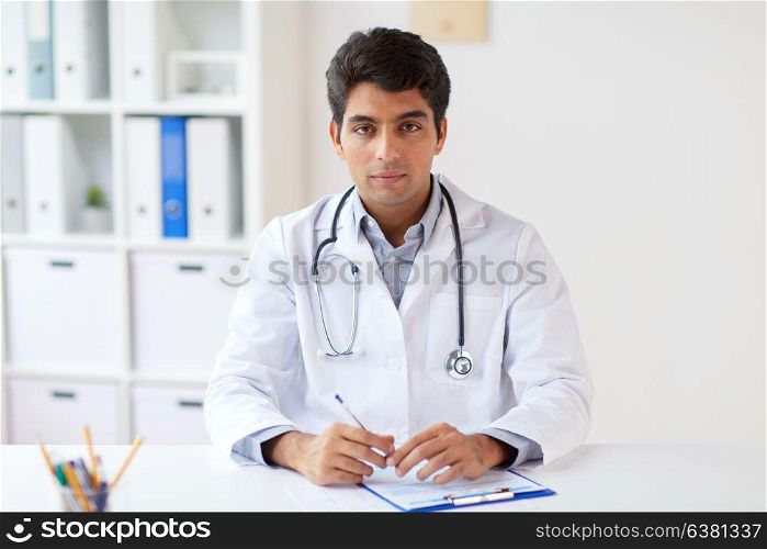 medicine, healthcare and people concept - male doctor with stethoscope and clipboard at clinic. doctor with stethoscope and clipboard at clinic