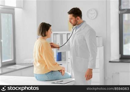 medicine, healthcare and people concept - male doctor with stethoscope and woman patient at hospital. male doctor with stethoscope and woman at hospital