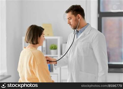 medicine, healthcare and people concept - male doctor with stethoscope and woman patient at hospital. male doctor with stethoscope and woman at hospital