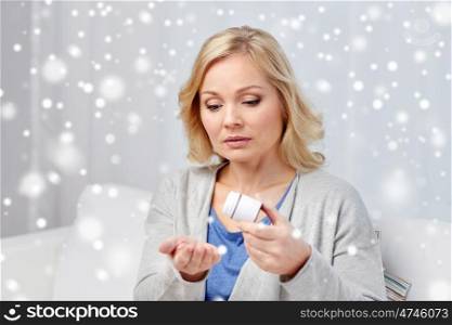 medicine, healthcare and people concept - middle aged woman with medication at home over snow
