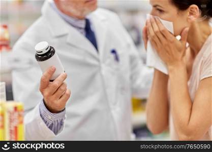 medicine, healthcare and people concept - senior apothecary shows drug to ill woman at pharmacy. apothecary shows medicine to ill woman at pharmacy