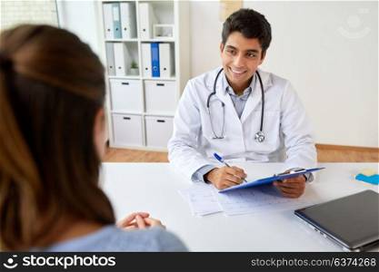 medicine, healthcare and people concept - smiling doctor with clipboard and patient at hospital. doctor with clipboard and patient at hospital
