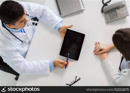 medicine, healthcare and people concept - smiling doctor with tablet pc computer and young woman meeting at hospital. smiling doctor and young woman meeting at hospital