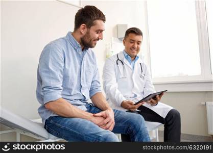 medicine, healthcare and people concept - smiling doctor with tablet pc computer and young man patient meeting at hospital. doctor with tablet pc and male patient at hospital