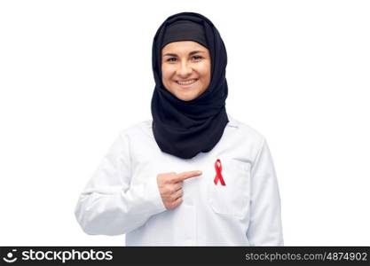 medicine, healthcare and people concept - smiling muslim female doctor wearing hijab and white coat with red aids awareness ribbon