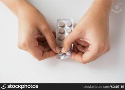 medicine, healthcare and people concept - woman hands opening pack of pills. woman hands opening pack of medicine pills