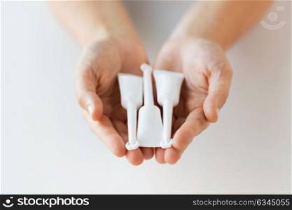medicine, healthcare and pharmaceutics concept - hands holding tubes of micro enema. hand holding tubes of micro enema