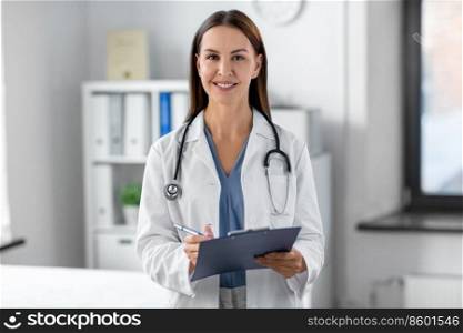 medicine, healthcare and profession concept - smiling female doctor with stethoscope and clipboard at hospital. smiling female doctor with clipboard at hospital