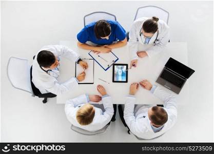 medicine, healthcare and surgery concept - group of doctors or surgeons discussing spine x-ray on tablet pc computer screen at hospital. doctors with spine x-ray on tablet pc computer