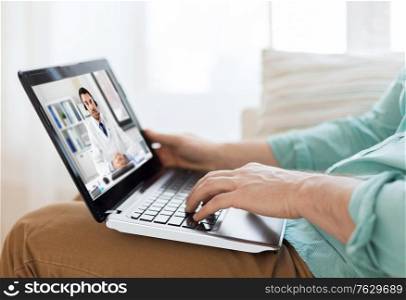medicine, healthcare and technology concept - close up of man having video call with male doctor on laptop computer. man having video call with male doctor on laptop