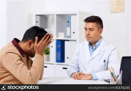 medicine, healthcare and technology concept - doctor and unhappy male patient meeting at hospital. doctor and unhappy male patient at hospital