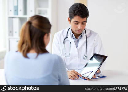 medicine, healthcare and technology concept - doctor showing tablet pc computer to patient at hospital. doctor showing tablet pc to patient at clinic