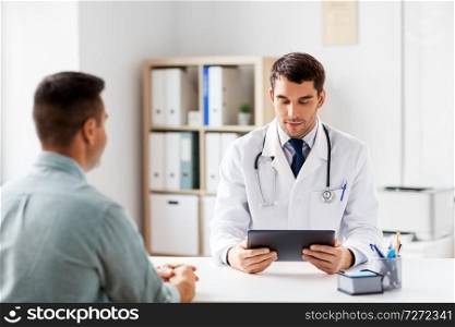 medicine, healthcare and technology concept - doctor with tablet pc computer and male patient at medical office in hospital. doctor with tablet computer and patient at clinic