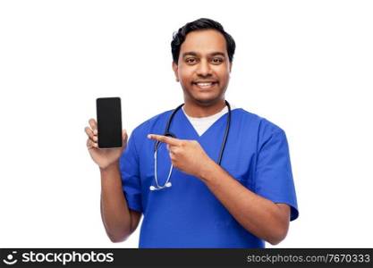 medicine, healthcare and technology concept - happy smiling indian doctor or male nurse in blue uniform with smartphone and stethoscope over white background. happy indian doctor or male nurse with smartphone