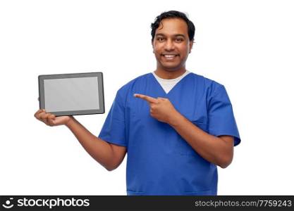 medicine, healthcare and technology concept - happy smiling indian doctor or male nurse in blue uniform showing tablet pc computer over white background. happy doctor or male nurse showing tablet computer