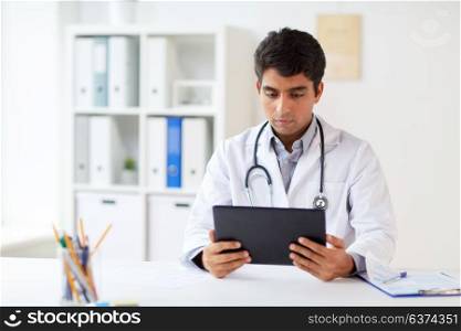 medicine, healthcare and technology concept - male doctor with tablet pc computer and stethoscope at clinic. doctor with tablet pc and stethoscope at clinic