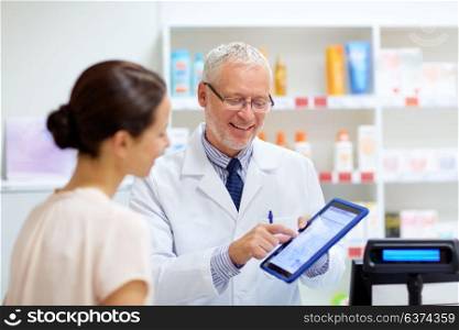 medicine, healthcare and technology concept - senior apothecary and female customer with digital prescription on tablet pc computer screen at pharmacy. apothecary and customer with tablet pc at pharmacy
