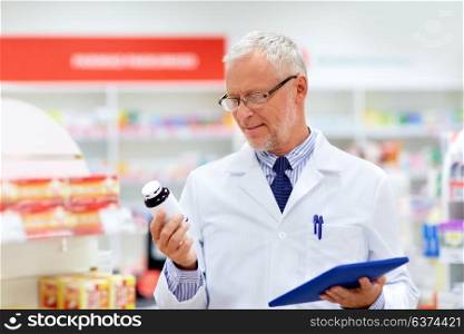 medicine, healthcare and technology concept - senior apothecary with tablet pc computer at pharmacy. senior with tablet pc at pharmacy
