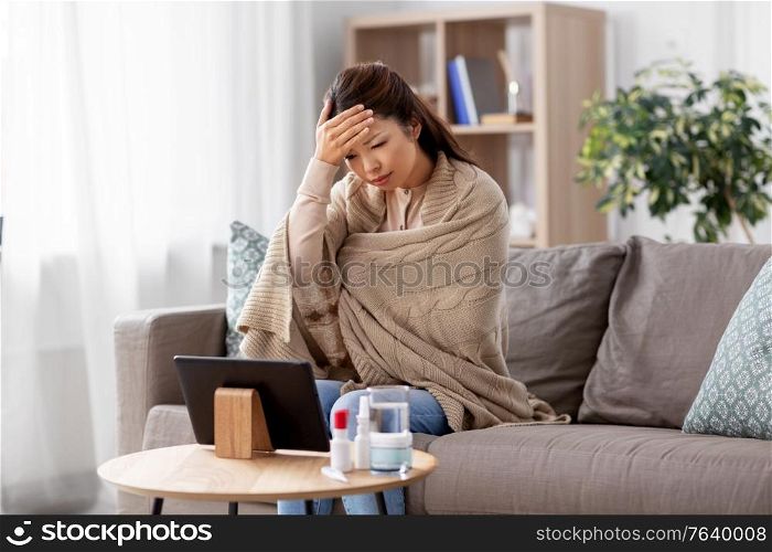medicine, healthcare and technology concept - sick young asian woman having video call or online consultation on tablet pc computer at home. sick woman having video call on tablet pc at home