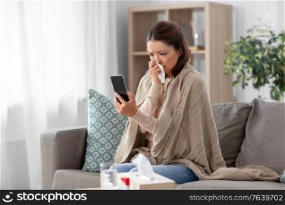 medicine, healthcare and technology concept - sick young asian woman with smartphone having video call or online consultation at home. sick asian woman with smartphone at home