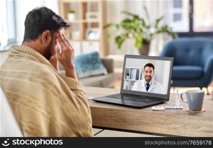 medicine, healthcare and technology concept - sick young man having video call or online medical consultation with doctor on laptop computer at home. sick man having video call with doctor at home