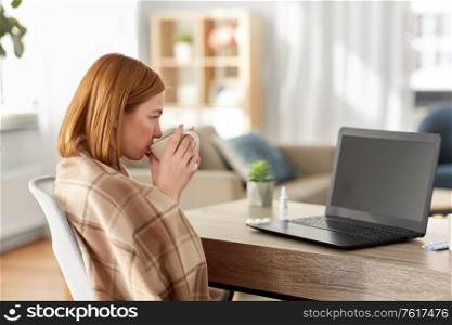 medicine, healthcare and technology concept - sick young woman having video call or online consultation on laptop computer and drinking tea at home. sick woman having video call on laptop at home