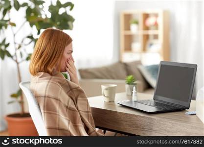 medicine, healthcare and technology concept - sick young woman having video call or online consultation on laptop computer at home and coughing. sick woman having video call on laptop at home
