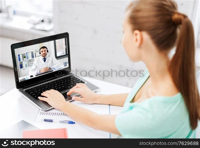 medicine, healthcare and technology concept - young woman having video call with male doctor on laptop computer. woman having video call with male doctor on laptop