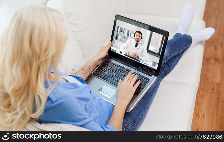 medicine, healthcare and technology concept - young woman having video call with male doctor on laptop computer. woman having video call with male doctor on laptop