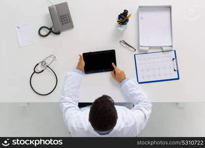 medicine, healthcare, cardiology and people concept - doctor with tablet pc computer and cardiogram sitting at table in clinic. doctor with tablet pc and cardiogram at clinic