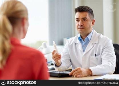 medicine, healthcare, medication and people concept - doctor with nasal spray and patient at hospital. doctor with nasal spray and patient at hospital