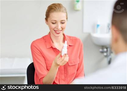 medicine, healthcare, medication and people concept - smiling woman with nasal spray and doctor at hospital. woman with nasal spray and doctor at hospital