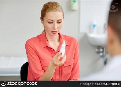 medicine, healthcare, medication and people concept - woman with nasal spray and doctor at hospital. woman with nasal spray and doctor at hospital