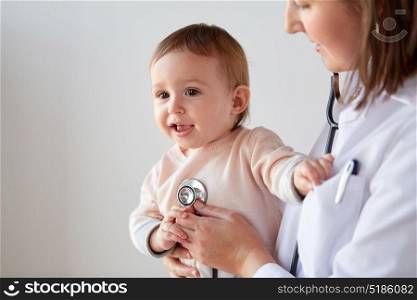 medicine, healthcare, pediatry and people concept - close up of doctor with stethoscope listening to baby on medical exam at clinic. doctor with stethoscope listening baby at clinic