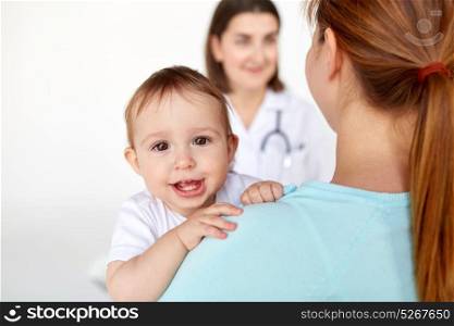 medicine, healthcare, pediatry and people concept - close up of happy baby with mother and doctor at clinic. close up of happy baby with mother and doctor