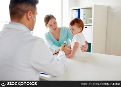 medicine, healthcare, pediatry and people concept - doctor with stethoscope listening to baby on medical exam at clinic. doctor with stethoscope listening baby at clinic