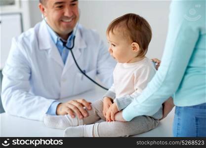 medicine, healthcare, pediatry and people concept - doctor with stethoscope listening to baby on medical exam at clinic. doctor with stethoscope listening baby at clinic