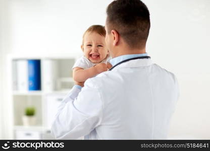 medicine, healthcare, pediatry and people concept - happy doctor or pediatrician holding baby on medical exam at clinic. happy doctor or pediatrician with baby at clinic