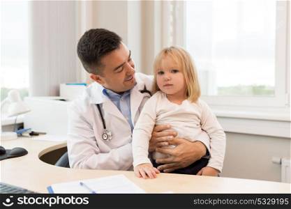 medicine, healthcare, pediatry and people concept - happy doctor or pediatrician holding little girl patient on medical exam at clinic. doctor or pediatrician with girl patient at clinic