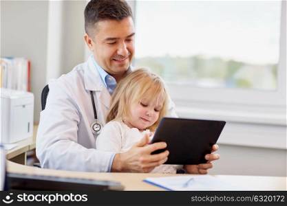 medicine, healthcare, pediatry and people concept - happy doctor or pediatrician holding little girl patient with tablet pc computer in medical office at clinic. doctor and little girl with tablet pc at clinic