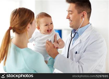 medicine, healthcare, pediatry and people concept - happy doctor with stethoscope listening to baby on medical exam at clinic. doctor with stethoscope and baby at clinic
