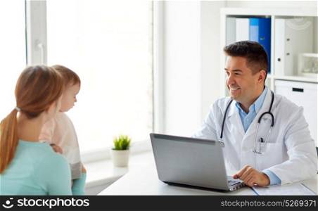 medicine, healthcare, pediatry and people concept - happy woman with baby and doctor with laptop computer at clinic. woman with baby and doctor with laptop at clinic