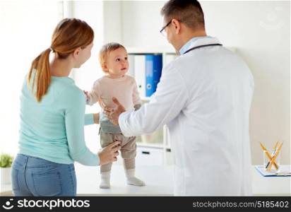 medicine, healthcare, pediatry and people concept - happy woman with baby and doctor at clinic. happy woman with baby and doctor at clinic