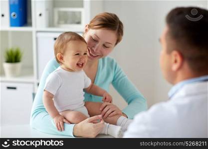 medicine, healthcare, pediatry and people concept - happy woman with baby and doctor at clinic. happy woman with baby and doctor at clinic