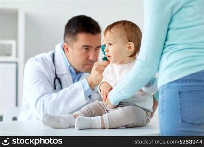 medicine, healthcare, pediatry and people concept - otolaryngologist or doctor checking baby ear with otoscope at clinic. doctor checking baby ear with otoscope at clinic