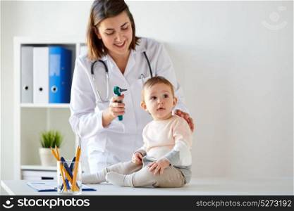 medicine, healthcare, pediatry and people concept - otolaryngologist or doctor with baby and otoscope at clinic. doctor with baby and otoscope at clinic